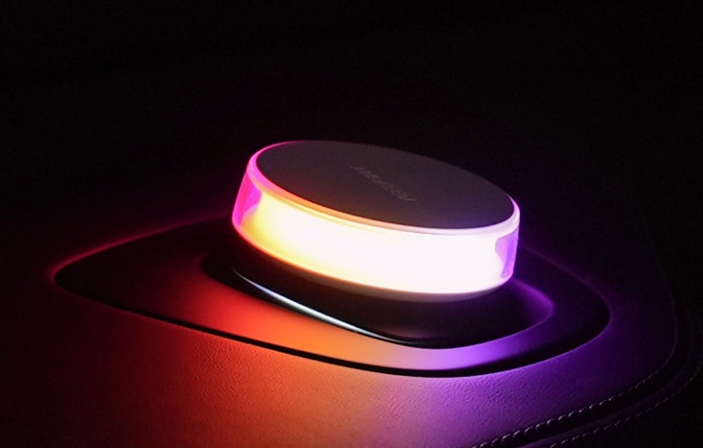 Lampa Yeelight Vega v aute, svietiaca intenzívnym ružovooranžovým svetlom.