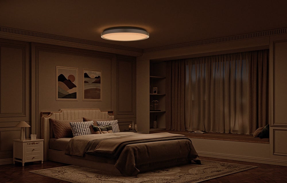 Útulná spálňa v teplých tónoch s posteľou a lampou Yeelight Jupiter D C500, ktorá svieti mäkkým, teplým svetlom.