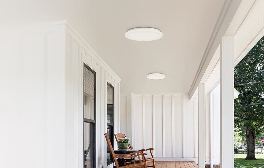 Dve stropné svietidlá Yeelight MercuryE C300 namontované na krytej verande s drevenou podlahou a hojdacím kreslom.