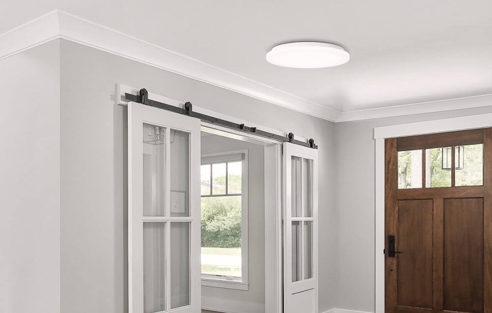 Svietidlo Yeelight MercuryE C260 namontované v svetlej hale s posuvnými dverami a drevenými vchodovými dverami.