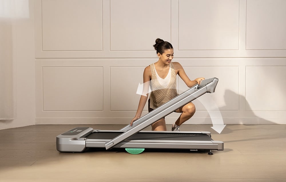 Žena skladajúca bežecký pás vo svetlej miestnosti