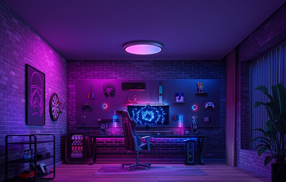 Herňa s fialovým a ružovým podsvietením, s lampou Yeelight Jupiter D C400 nad počítačovou pracovnou stanicou.