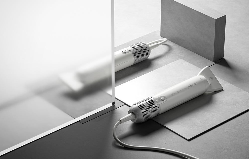 Dve biele sušičky ležia na sivých geometrických plochách v minimalistickom usporiadaní