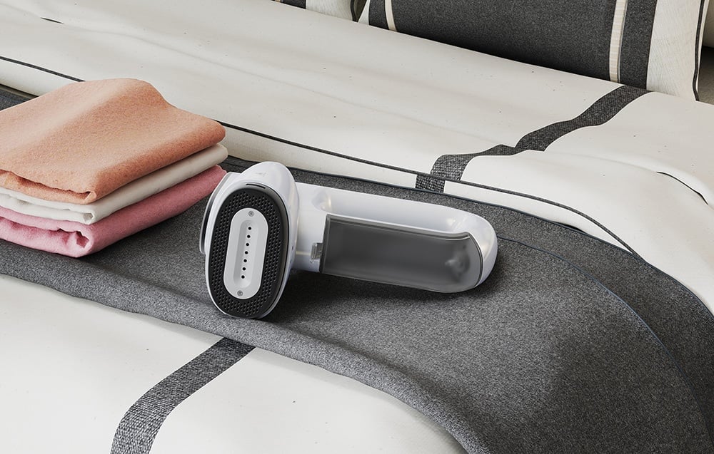 Biely naparovač leží na posteli vedľa hromady farebných uterákov