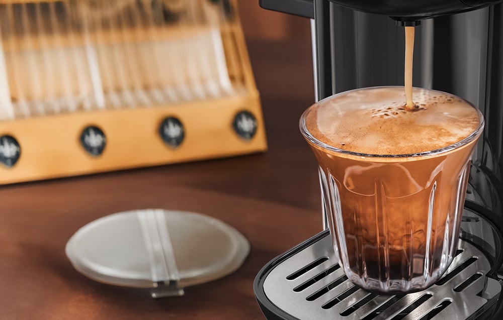 Detailný záber procesu extrakcie kávy s hustou penou creama.