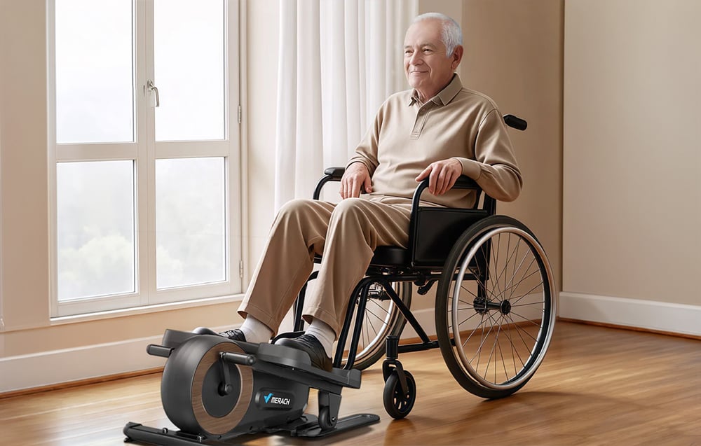 Starší muž na invalidnom vozíku cvičí nohy na mini eliptickom trenažéri Merach.
