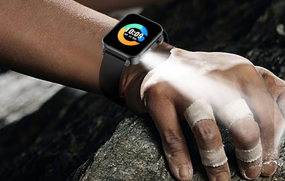 Inteligentné hodinky s baterkou na zápästí muža.