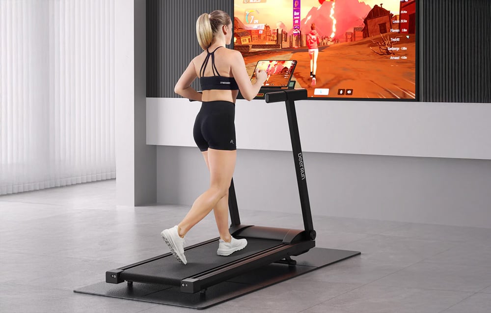 Žena cvičí na bežeckom páse v modernom interiéri a pozerá sa na obrazovku s fitness hrou
