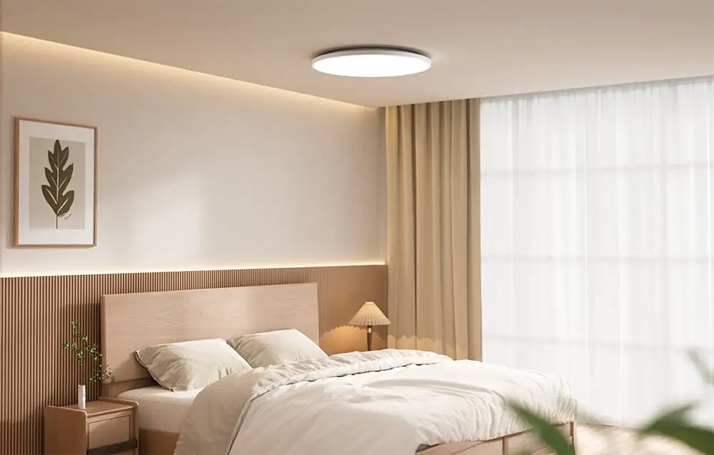 Svetlá spálňa s posteľou a zapnutým stropným svietidlom Yeelight Mercury C300.